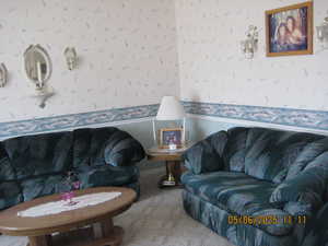 Living area with wallpapered walls and carpet floors