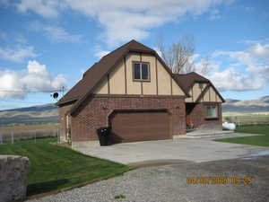 View of home's exterior with concrete driveway, a mountain view, stucco siding, and fence