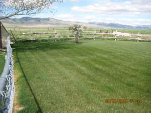View of yard with a mountain view, a rural view, and fence