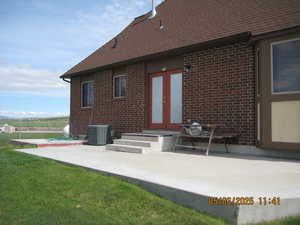 Back of house with french doors, fence, central AC unit, a patio area, and brick siding