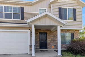 Entrance to property featuring stone siding