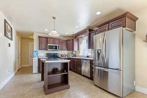 Kitchen with stainless steel appliances, recessed lighting, a center island, open shelves, and light countertops