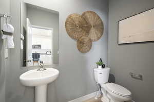Half bath featuring toilet and baseboards