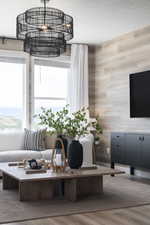 Living area featuring wooden walls, a textured ceiling, and wood finished floors