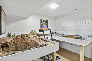 Bedroom featuring a textured ceiling, baseboards, visible vents, and carpet floors