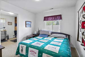 Bedroom featuring carpet flooring, baseboards, and visible vents