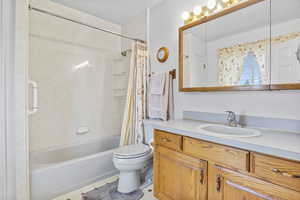 Full bath featuring tile patterned floors, toilet, shower / tub combo, and vanity