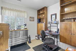 Office area with a textured ceiling, visible vents, and baseboards