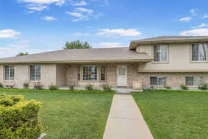 Tri-level home featuring brick siding and a front lawn