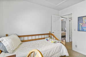 Bedroom with carpet, attic access, and baseboards