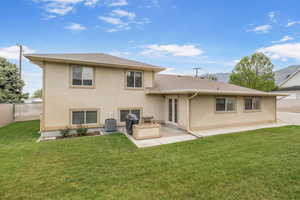 Back of house with a lawn, stucco siding, fence, and a patio