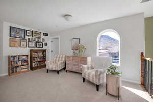 Sitting room with light colored carpet, a mountain view, and baseboards