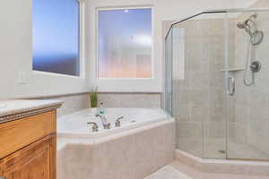Bathroom with a bath, vanity, and a shower stall