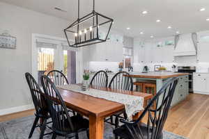 Dining room featuring baseboards, visible vents, recessed lighting, a notable chandelier, and light wood-style floors