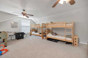 Bedroom with lofted ceiling, carpet flooring, a ceiling fan, and baseboards