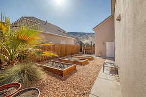 View of yard featuring fence, a mountain view, and a garden