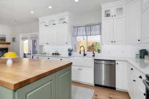 Kitchen with recessed lighting, dishwasher, wooden counters, and a sink