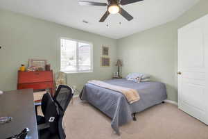 Bedroom featuring light carpet, baseboards, a ceiling fan, and visible vents
