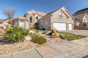 View of front of home with stone siding, driveway, a garage, stucco siding, and a tiled roof