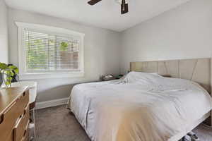 Bedroom featuring baseboards, a ceiling fan, and carpet