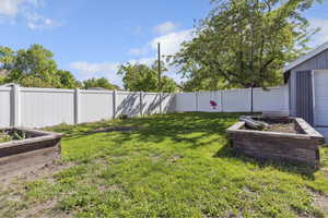 View of yard featuring a garden and a fenced backyard