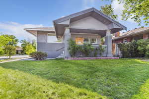 View of front facade featuring stucco siding, a front lawn, and brick siding