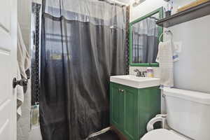 Full bathroom with toilet, shower / tub combo, and vanity
