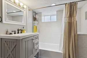 Bathroom featuring vanity, a textured ceiling, and shower / bath combo