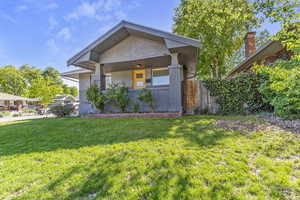 View of front facade with fence, brick siding, and a front yard