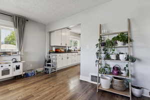 Interior space featuring backsplash, a sink, a textured ceiling, and wood finished floors