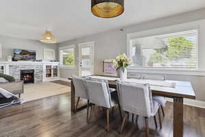 Dining space featuring a fireplace, baseboards, and dark wood-type flooring