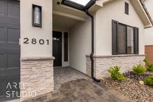 Property entrance featuring stone siding and stucco siding