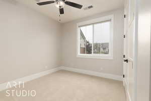 Empty room with light colored carpet, baseboards, and ceiling fan