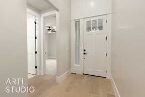 Entrance foyer featuring light wood finished floors, baseboards, and ceiling fan