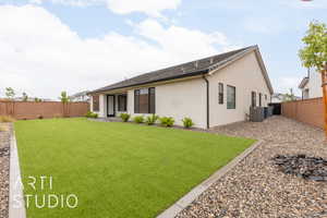 Rear view of property featuring central air condition unit and stucco siding