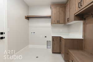 Clothes washing area with electric dryer hookup, hookup for a washing machine, cabinet space, and baseboards