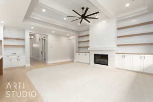 Unfurnished living room featuring a barn door, a ceiling fan, light wood-type flooring, recessed lighting, and beamed ceiling