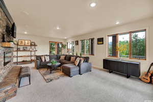 Carpeted living room featuring a fireplace, baseboards, and recessed lighting