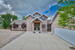 View of front of property featuring a shingled roof, brick siding, french doors, and a garage
