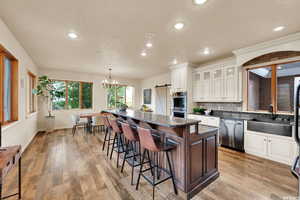 Kitchen featuring a barn door, a center island, a sink, a kitchen bar, and stainless steel appliances