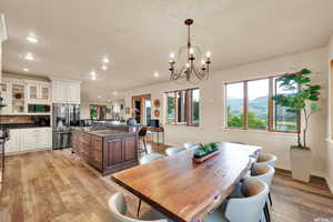 Dining room featuring light wood-type flooring, a wealth of natural light, a chandelier, and recessed lighting