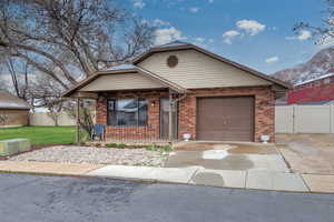 View of front of house featuring covered porch, a garage, a front lawn, brick siding, and driveway