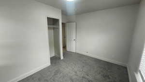 Unfurnished bedroom with baseboards, carpet flooring, and a closet