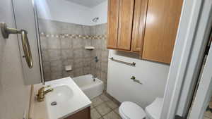 Full bathroom with tile patterned floors, toilet, tub / shower combination, and vanity