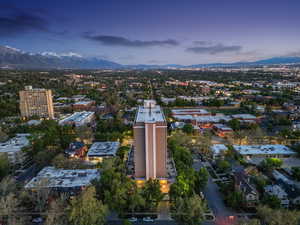Aerial view of property and surrounding area featuring mountains and nearby urban area