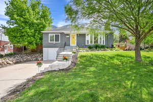 View of front of home with fence, an attached garage, a front lawn, and driveway