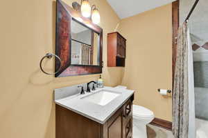 Full bath with toilet, tile patterned flooring, vanity, and a shower with shower curtain