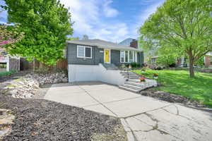 View of front of home with fence, driveway, a garage, a front yard, and a chimney