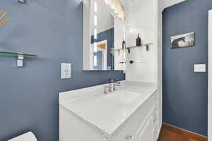 Bathroom featuring baseboards, vanity, and toilet