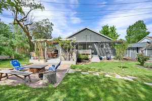 Rear view of house with a yard, fence, a patio, an outdoor fire pit, and a deck